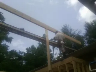 Carpenter setting a ridge beam over a new addition frame — Ice Dam Removal by Roofing Brothers in Chemung
