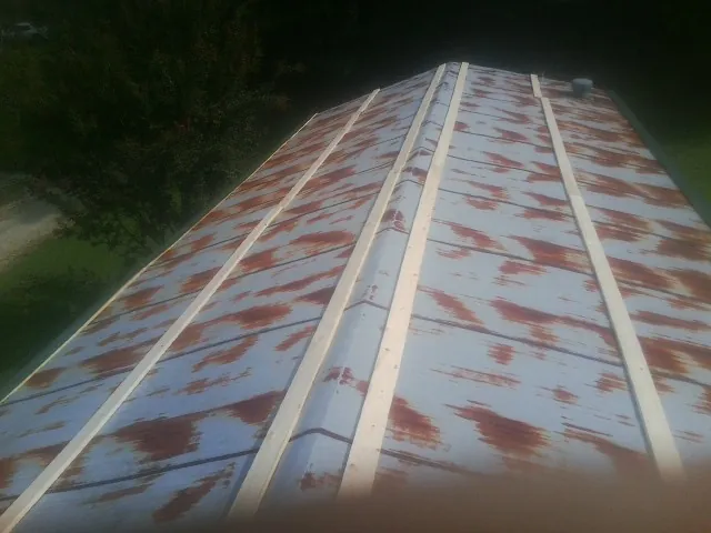 Rusted metal roof panels with new wood purlins before replacement — Storm Damage Roof Repair in Chemung by Roofing Brothers