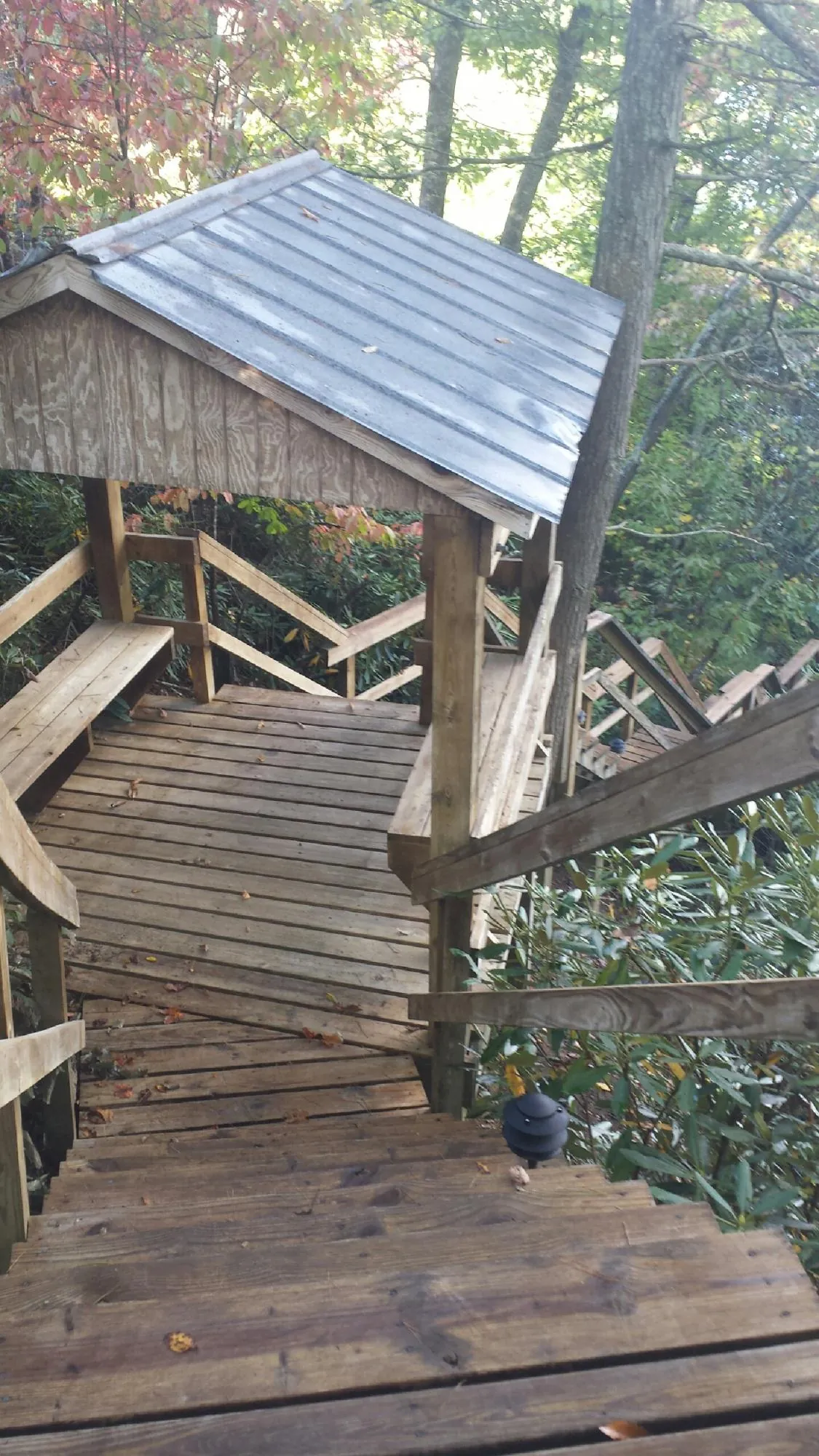 Metal roofed shelter over wooden steps on a wooded walkway — Skylight Repair & Installation work by our crew in Chemung