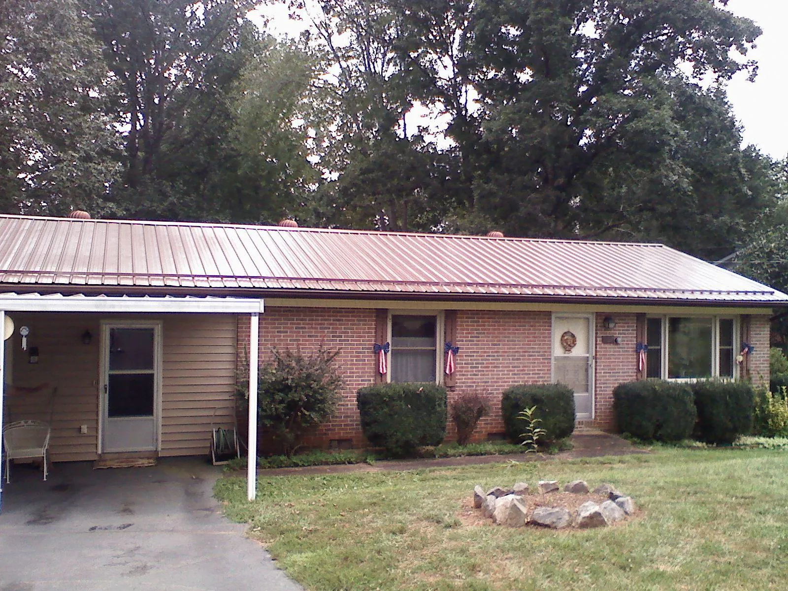 Bronze metal roof and carport on a brick ranch home — Roof Repair work by our crew in Chemung